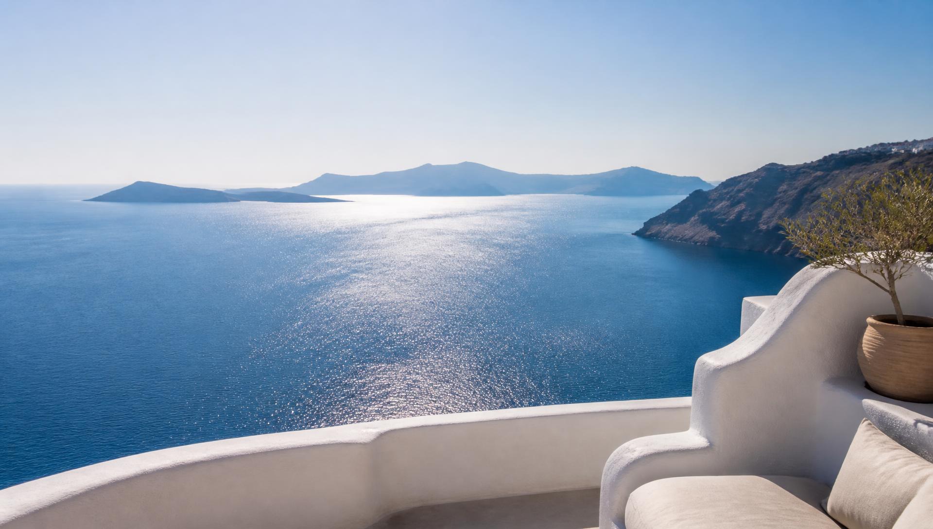 A sunlit whitewashed terrace overlooking the deep blue Aegean Sea and distant Greek islands